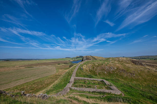 A milecastle was a small fort (fortlet), a rectangular fortification built during the period of the Roman Empire. They were placed at intervals of approximately one Roman mile along major frontiers, for example this one, which is Milecastle 39 on Hadrian's Wall in Great Britain. Begun in 122, Hadrian's Wall itself is a stone or turf and timber fortification, 73.5 miles (117 km) long, built by the Roman Empire across the width of what is now northern England, from Newcastle upon Tyne to Carlisle.