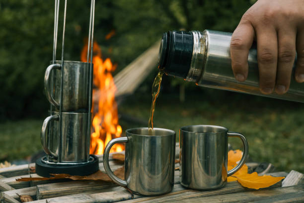istock Themed trip. The man pours a hot drink into the thermos 2177985143