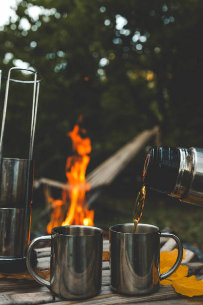 istock Themed trip. The man pours a hot drink into the thermos 2177985145