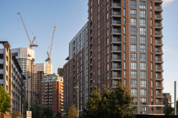High-rise residential buildings, accompanied by construction cranes, dominate the skyline in Leeds. The scene captures the city's rapid urbanization and architectural transformation under a clear, golden-hour sky.