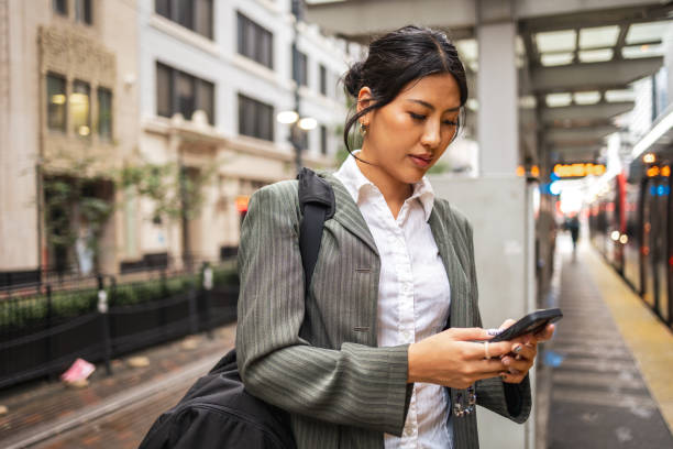 istock Businesswoman using smartphone while waiting at city train station 2177987940