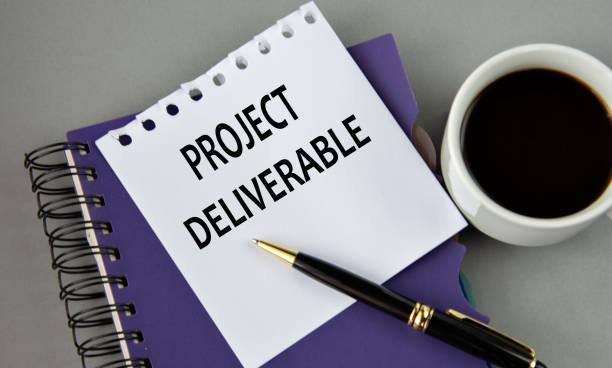 istock PROJECT DELIVERABLE - words on a white sheet with a cup of coffee 2177988922