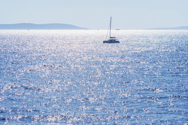 istock Sparkling sea in backlight with ship, island in the background, at sunset 2177992538