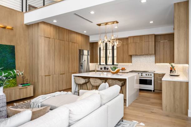 istock Modern kitchen interior with wooden cabinets, white countertops, and elegant lighting 2177995314