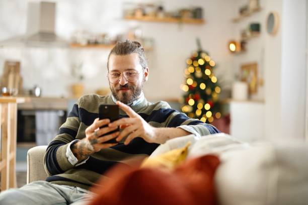 Man texting on his smartphone while sitting in the living room