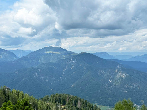 istock Majestic mountain landscape with cloudy sky and verdant forest below 2178003098