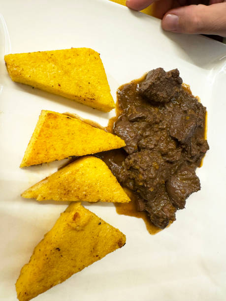 Savory braised beef stew with crispy polenta triangles on elegant plate