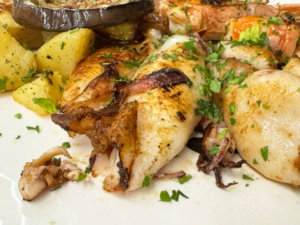istock Grilled seafood platter with squid and vegetables garnished with fresh herbs 2178003950
