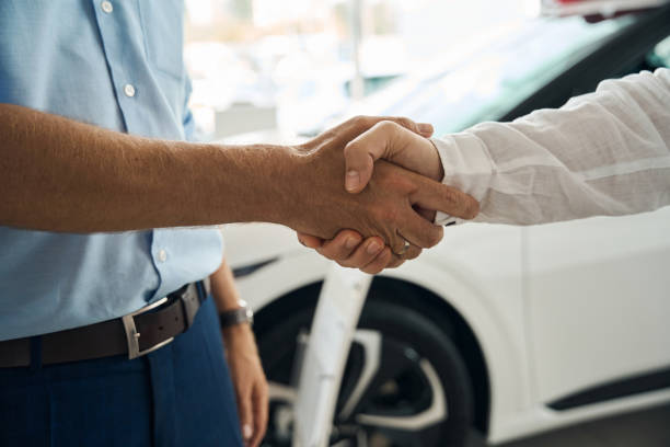 istock Salesman shaking hands with client in modern car dealership 2178005032