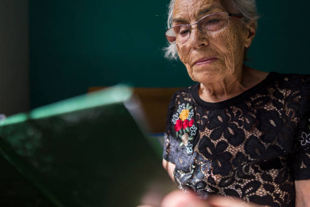 istock Elderly Woman Reading A Book in Embroidered Lace Top 2178010182