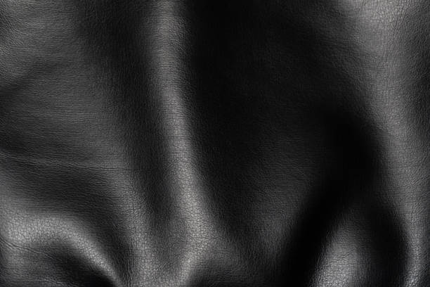 Soft faux leather texture with deep folds. Black background.