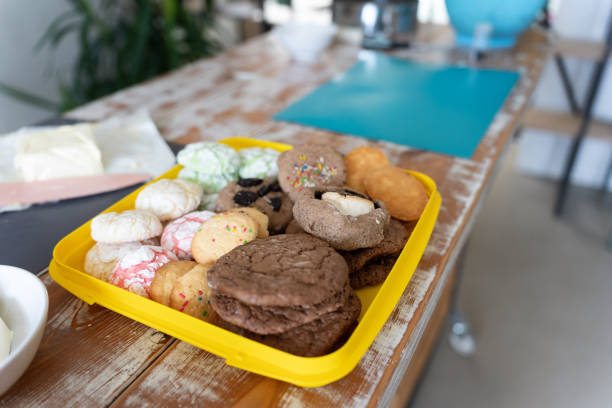 A variety of homemade cookies displayed on a yellow tray in a rustic kitchen setting, offering a warm and inviting atmosphere perfect for dessert lovers.