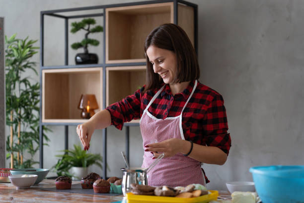 Smiling Woman Baking Homemade Muffins in Her Kitchen