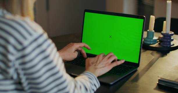 istock A woman uses a laptop with green screen 2178017940