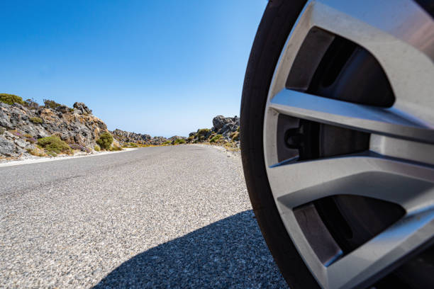 istock Car wheel on the road lined with rocks in the sun 2178018930
