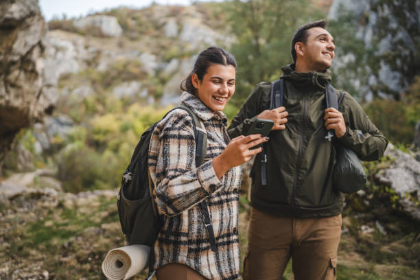 istock couple take a break from hiking and use mobile phone having fun 2178021463
