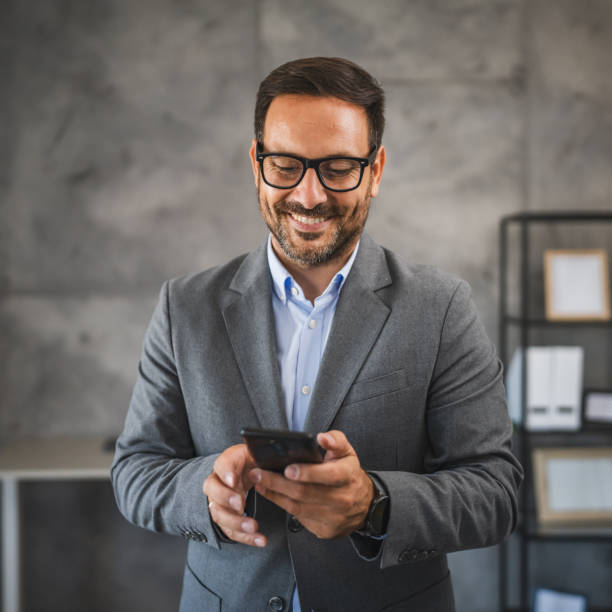 istock confident businessman use mobile phone and smile in modern office 2178021762
