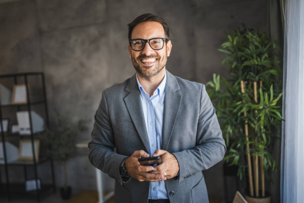istock confident businessman use mobile phone and smile in modern office 2178021873