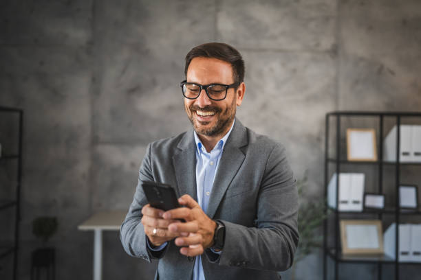 istock confident businessman use mobile phone and smile in modern office 2178021876