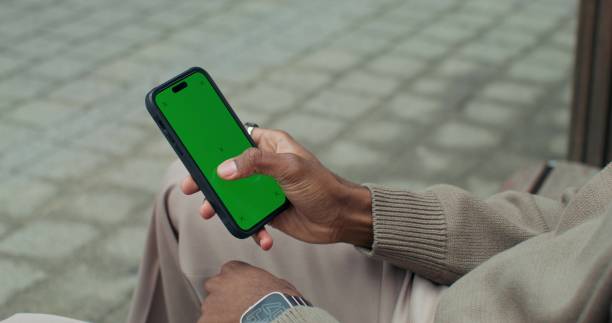 istock A man uses a mobile phone sitting outdoors 2178022542
