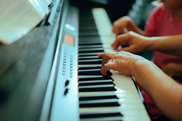 istock Teacher Showing Kid How to Play Piano 2178024921