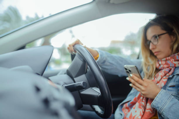 istock A female driver uses a smart phone while driving. 2178025917