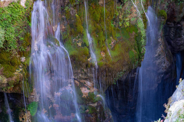 Mossy rocks and waterfall in Kourtaliotiko gorge, blurred water, diffused light, Greece, Crete island, wide angle lens