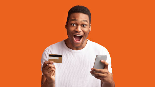 istock Black man holding credit card and cellphone at studio 2178032278