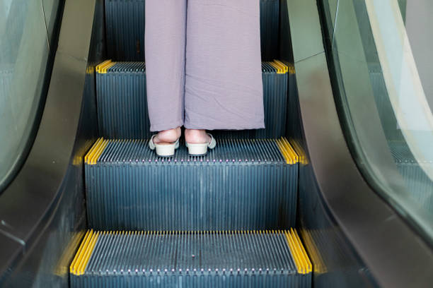 istock Feet on Escalator with Yellow Safety Markings 2178038892