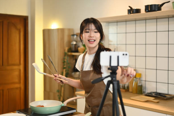 istock Cheerful young woman recording a cooking tutorial in a modern kitchen 2178040384