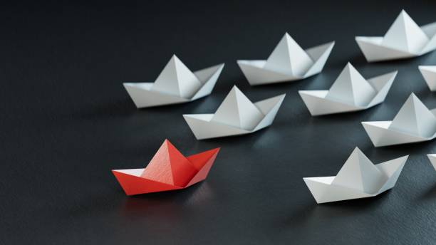 istock Different business concept.new ideas. paper art style. creative idea.Leadership concept with red paper ship leading among white.3D rendering on black background. 2178046998