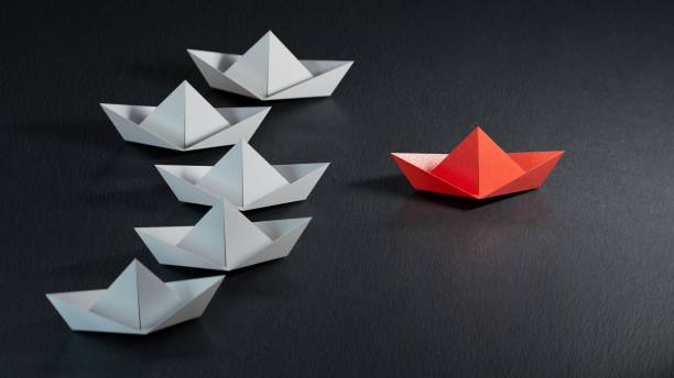 istock Different business concept.new ideas. paper art style. creative idea.Leadership concept with red paper ship leading among white.3D rendering on black background. 2178047013
