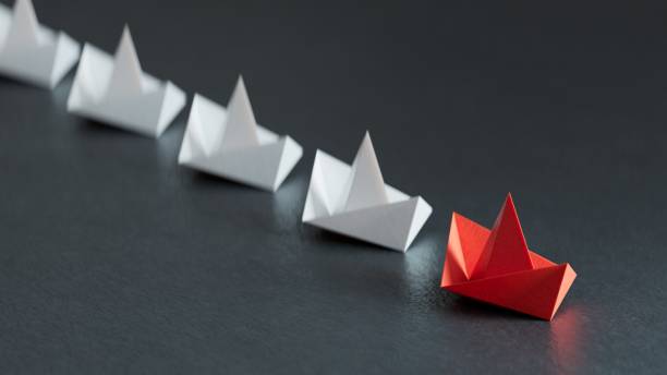 istock Different business concept.new ideas. paper art style. creative idea.Leadership concept with red paper ship leading among white.3D rendering on black background. 2178047042