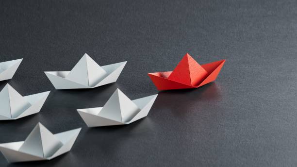 istock Different business concept.new ideas. paper art style. creative idea.Leadership concept, red paper ship leading among white.3D rendering on black background. 2178047095