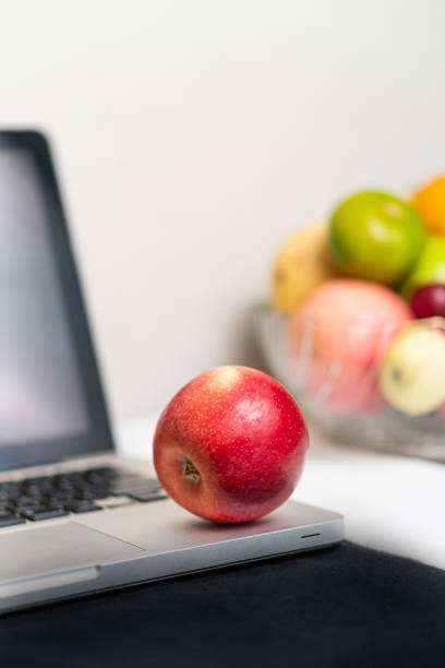 istock Red Apple on Laptop with Assorted Fruits 2178048579