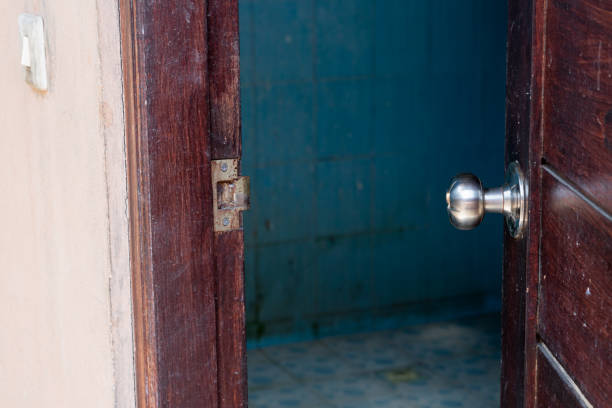 istock Partially Open Wooden Door with Blue-Tiled Room 2178049682