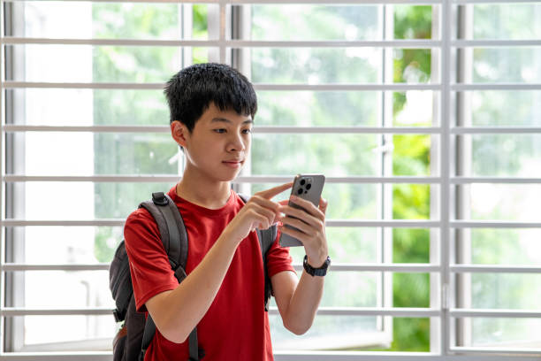 istock Young Asian doing mobile banking in school 2178049838