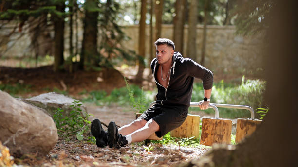 istock Young Man Performing Dips on Parallel Bars Outdoors, Upper Body Strength Training in a Natural Setting 2178050192