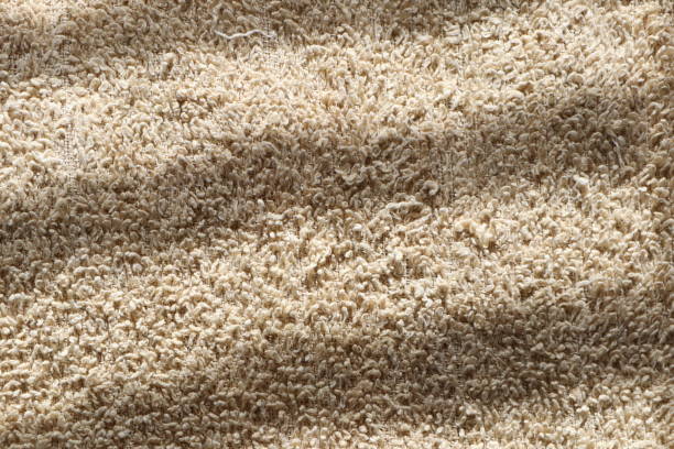 istock The Textured Surface of a Beige Carpet Enhanced by Shadows Cast from Natural Light 2178051915
