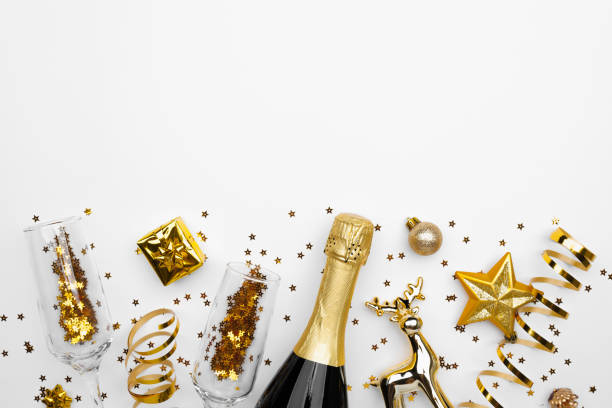 istock A champagne bottle with gold decorations and confetti on white 2178053354