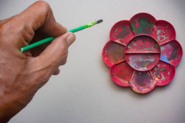 Hand holding a painting brush