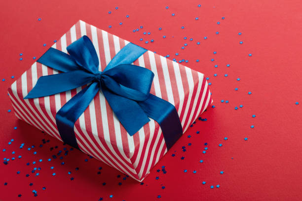 istock A red and white gift box with a blue bow on a red background 2178054773