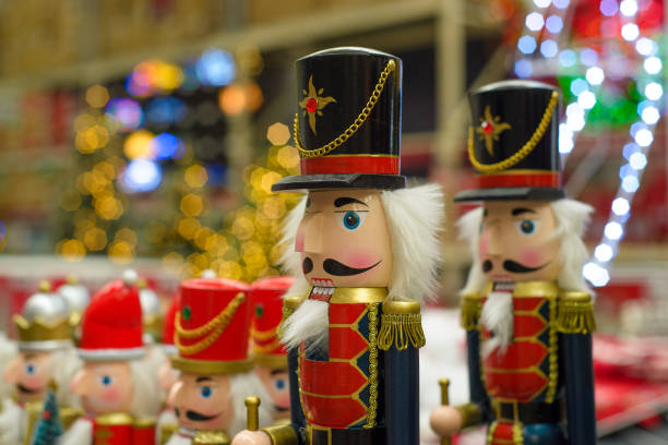 A close-up of a traditional wooden nutcracker soldier toy with a red and gold uniform, white beard, and blue eyes.