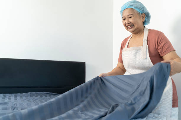 istock Cheerful Housekeeper is making the bed in house or apartment 2178055593