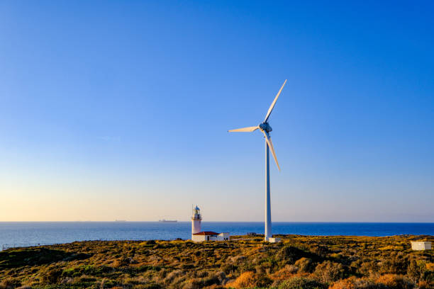 Old fashioned vintage windmill with metal sails and timber construction sat in the distant with an old street light in the front of the image