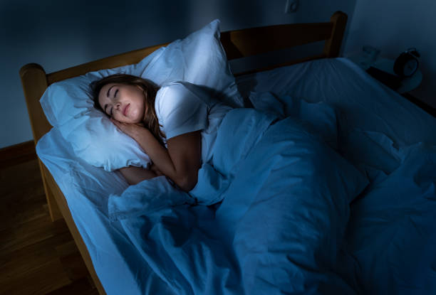 istock Woman sleeping in bed in morning at sunrise 2178070242