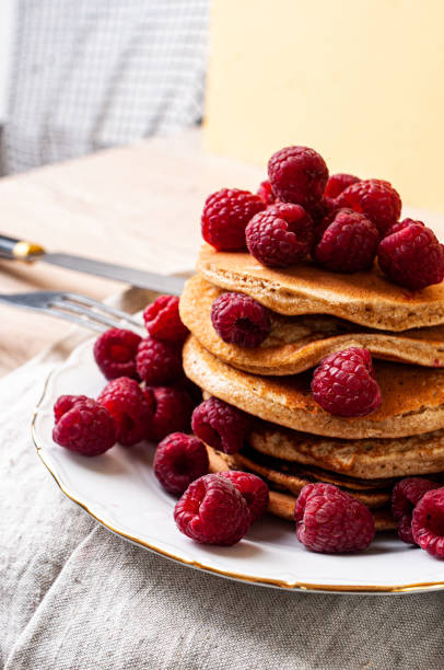 istock Delicious whole wheat healthy pancakes with raspberry, fork and knife styling natural light and copy space on the table with linen cloth background lifestyle 2178074386