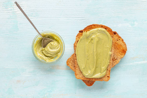 Grain bread toast with pistachio cream lying on plain toast. Top view