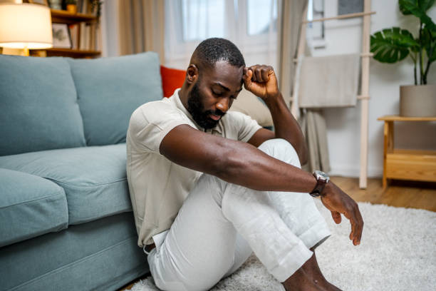 istock Depressed man sitting alone on the floor 2178077030