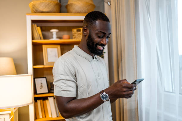 istock Young cheerful man using phone at home 2178077147